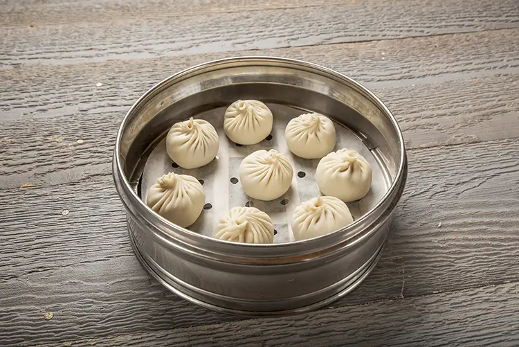 Juicy soup dumplings steamed in a metal bamboo basket at P P Pop Taiwanese Noodle Restaurant, a Taiwanese Restaurant in Monterey Park